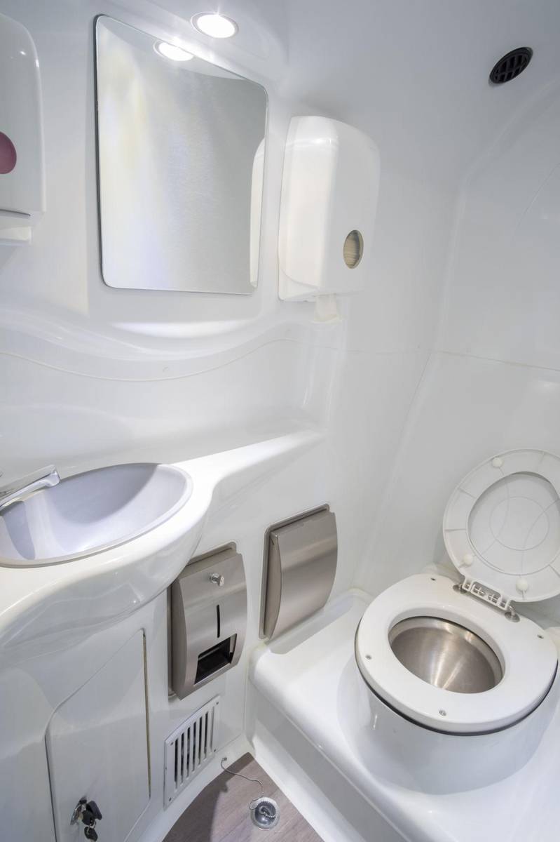 Bus toilet installed in luxury coach with mirror and tissue dispenser